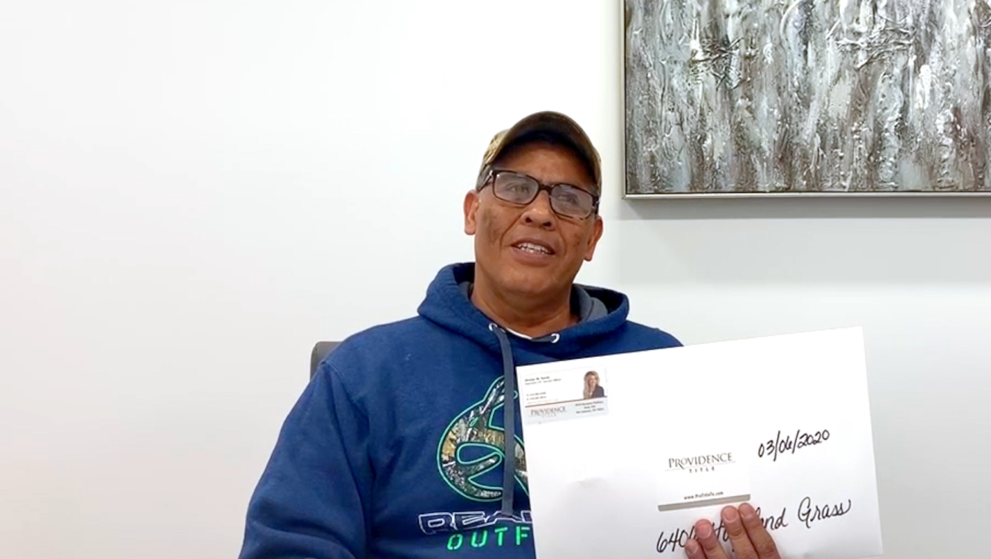 A seller holding their closing envelope at the title company